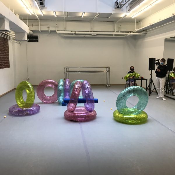 Multi-Colored, glittery inflatable inner tubes are arranged artfully in a dance studio.