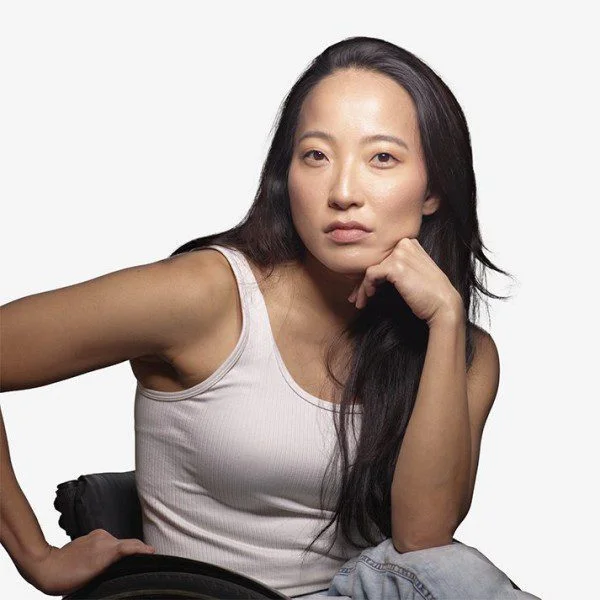 2023AXIS_JulieHasushi_byDavidSilva_Square A headshot of Julie, a woman of Japanese descent from Brazil. She has long black hair and wears a white tank top.