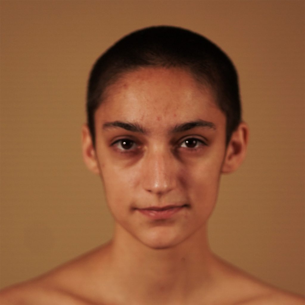 August Grace (a thin, white, nonbinary individual) looks directly at the camera.