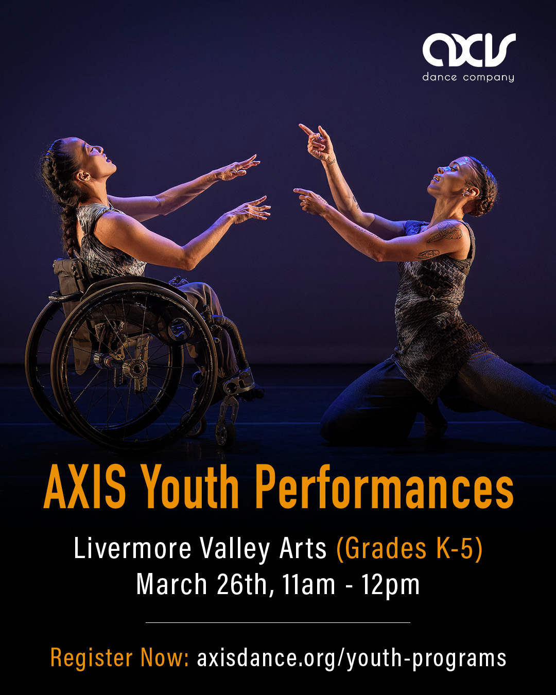 AXIS dancers Julie and Alaja point two fingers at each other and smile while performing on stage. Julie uses a wheelchair and Alaja crouches down; both dancers wear silvery costumes reminiscent of moonscapes.